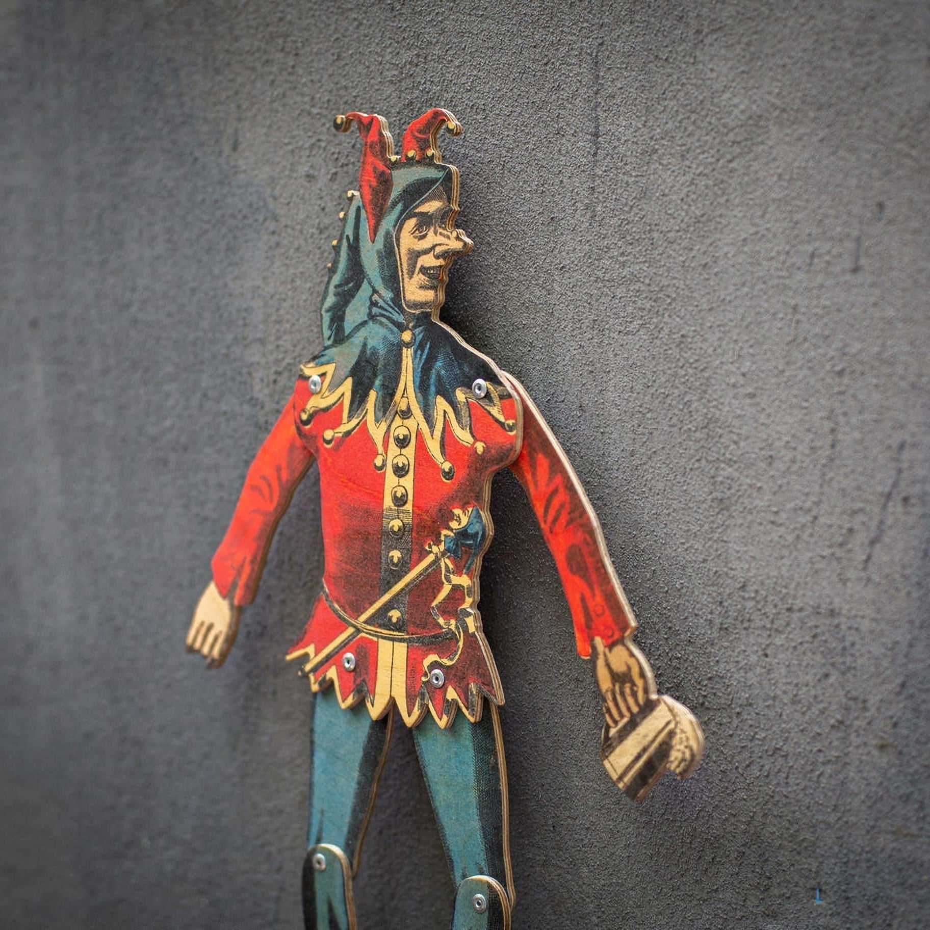 close up of handmade articulated plywood jester puppet showing printed details and joints