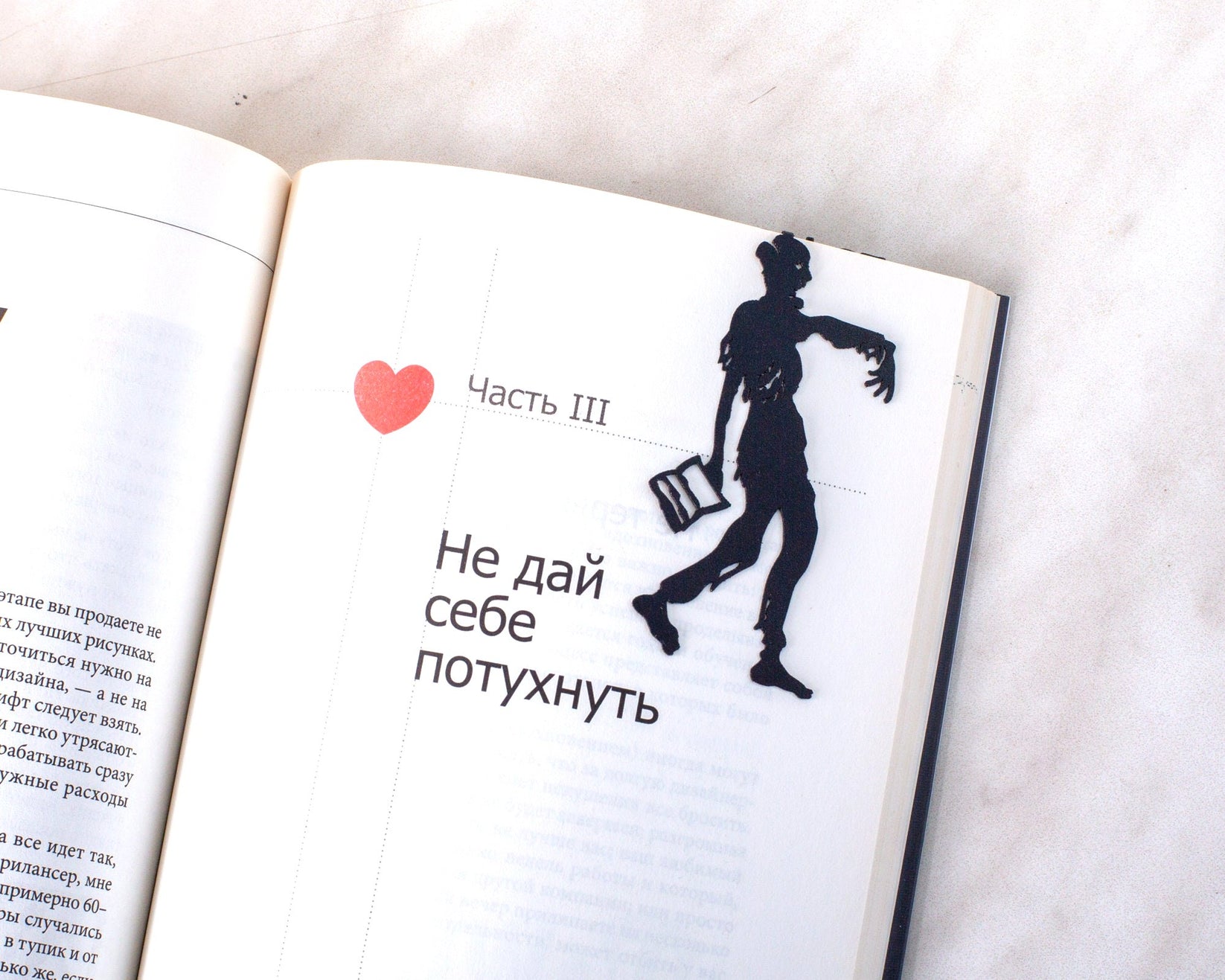Zombie Walking Dead metal bookmark resting on the pages of an open book