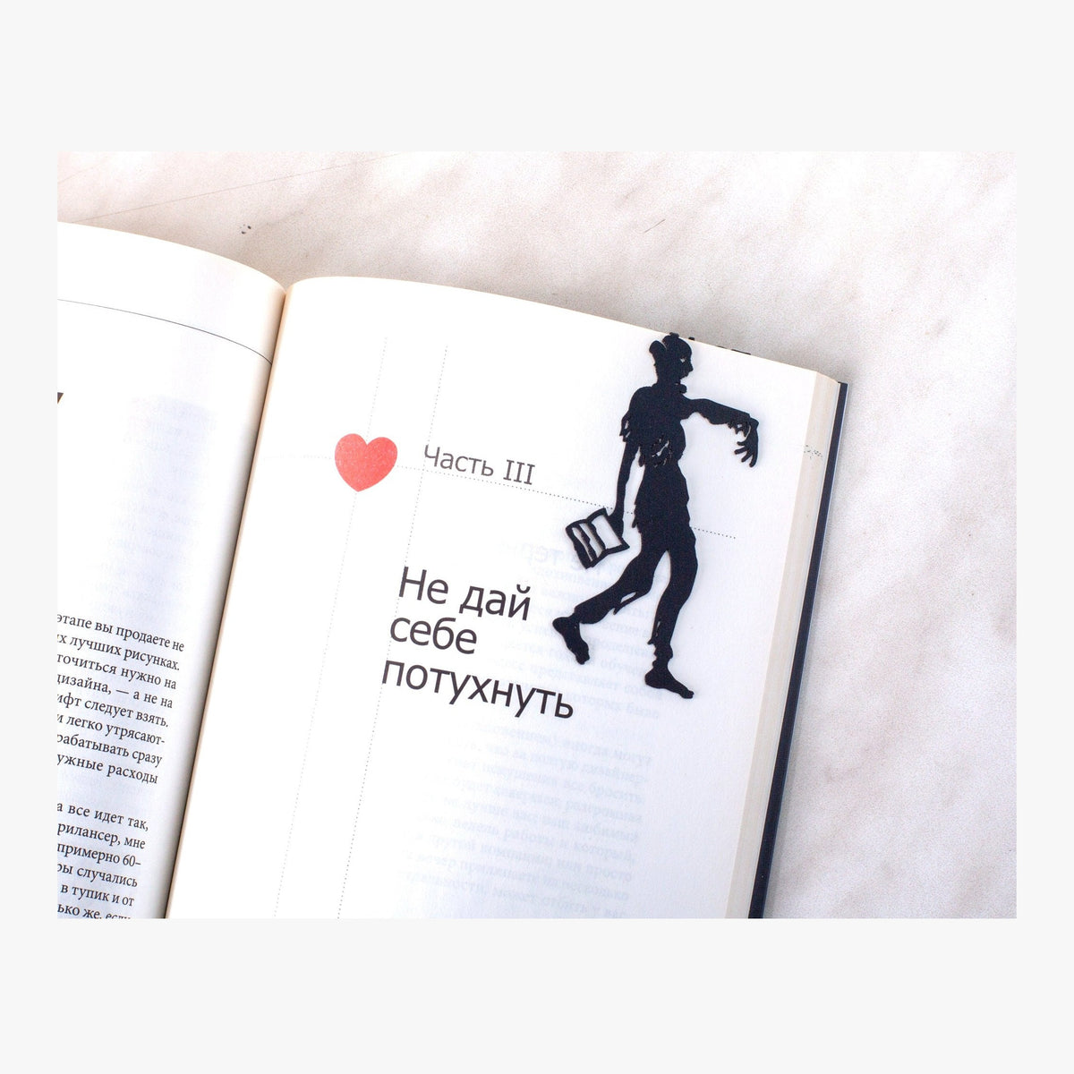 Zombie Walking Dead metal bookmark resting on the pages of an open book